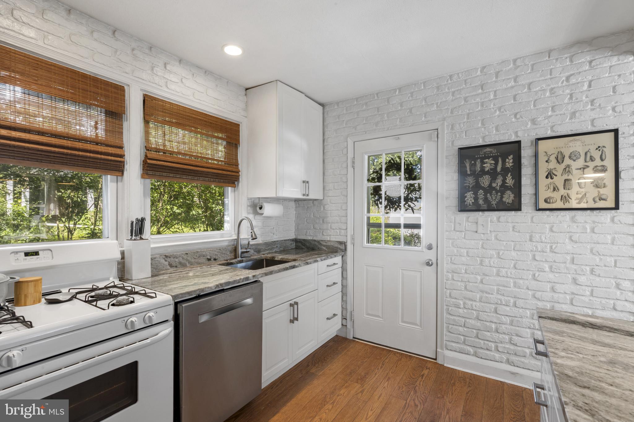 6500 Sharon Road Baltimore, MD 21239 - Photo 8 of 33 a kitchen with a stove a sink a window and wooden floor