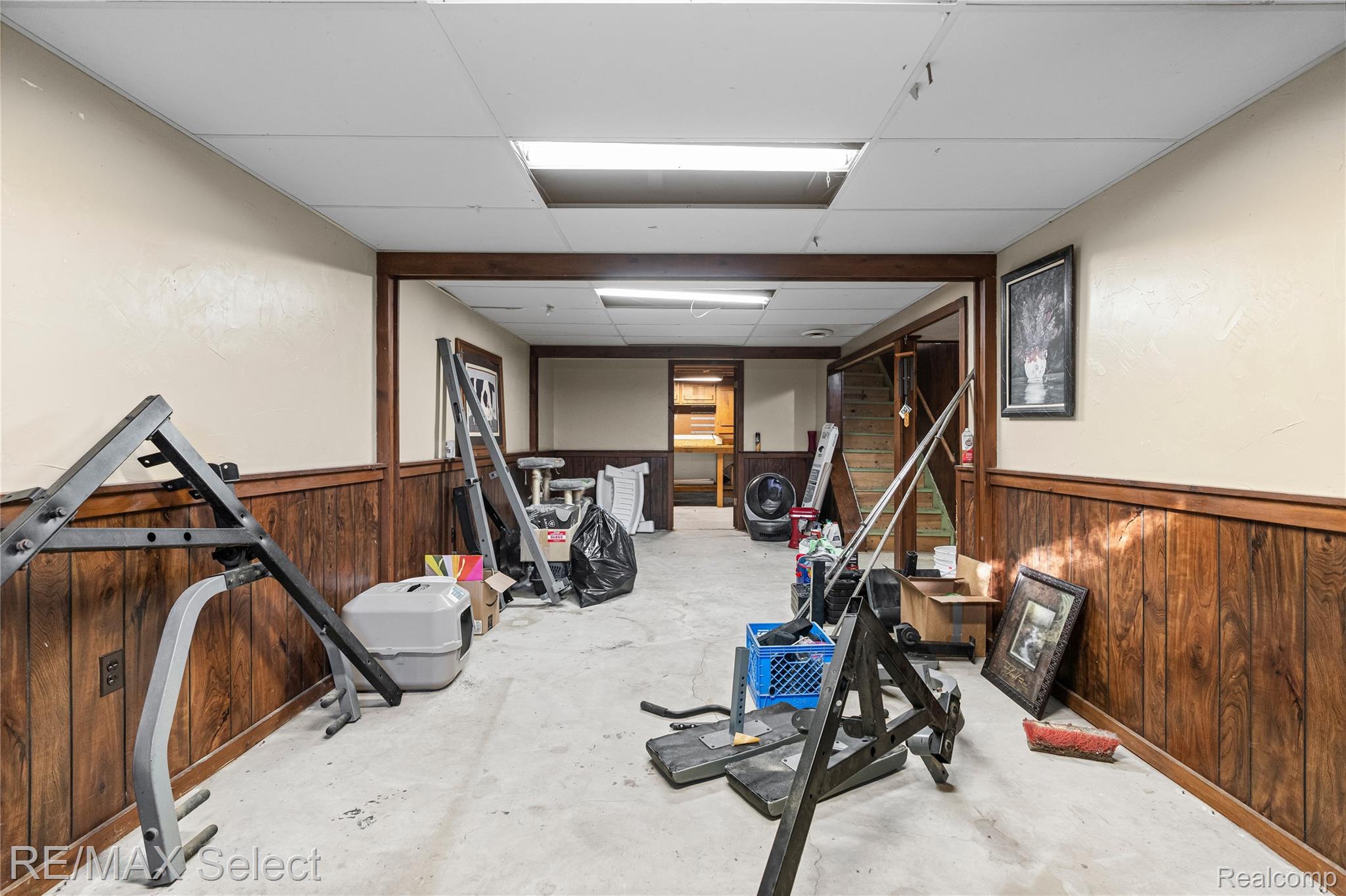 6393 East Frances Road Mount Morris, MI 48458 - Photo 26 of 37 Workout room featuring a drop ceiling, concrete floors, wooden walls, and a wainscoted wall