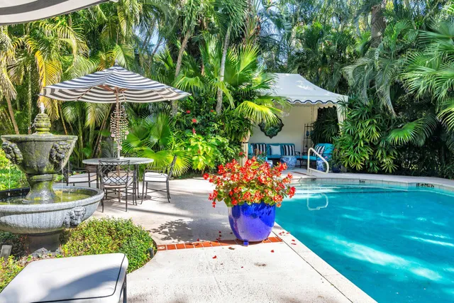 a view of a tables and chairs in patio with a garden