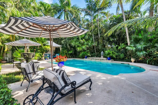 a view of a patio with a table and chairs under an umbrella