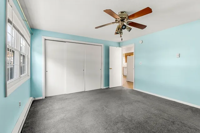 an empty room with fan and windows