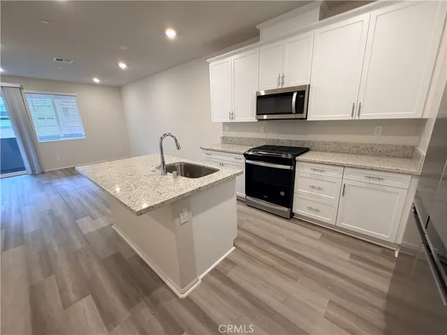 a kitchen with granite countertop a stove and a sink