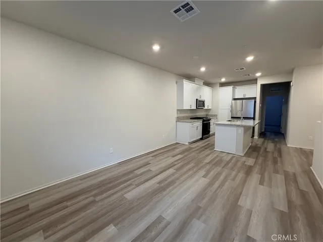 a view of kitchen with wooden floor and electronic appliances