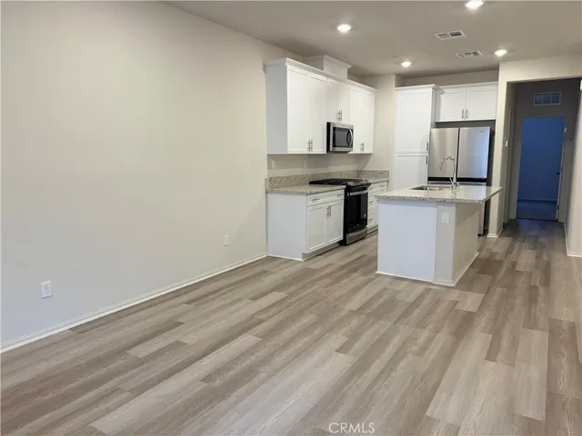 a kitchen with granite countertop white cabinets and stainless steel appliances