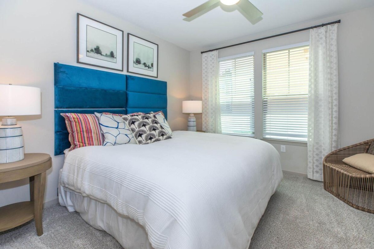 907 S Road, Unit 7202 Baytown, TX 77521 - Photo 10 of 12 a bedroom with a bed and a chandelier