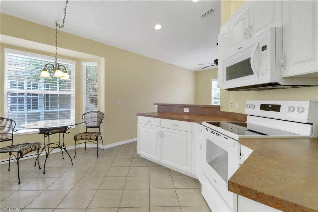 20141 Seagrove Street, Unit 308 Estero, FL 33928 - Photo 12 of 36 a kitchen with cabinets and chairs