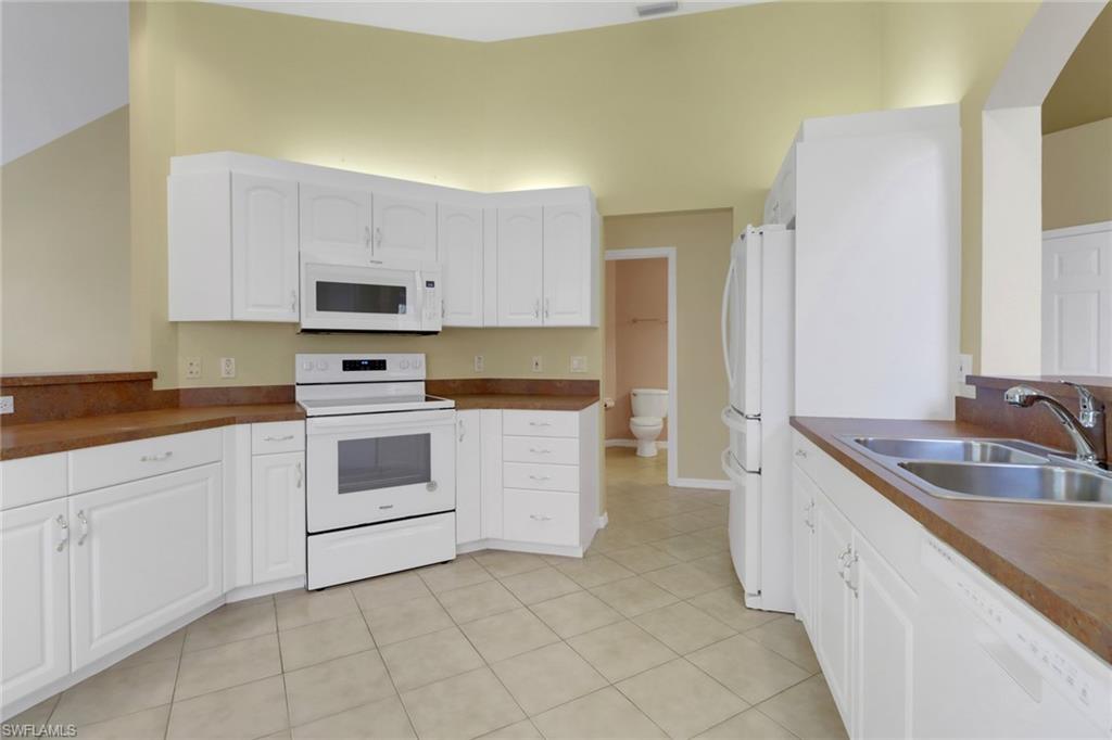20141 Seagrove Street, Unit 308 Estero, FL 33928 - Photo 13 of 36 a kitchen with a sink stove and cabinets