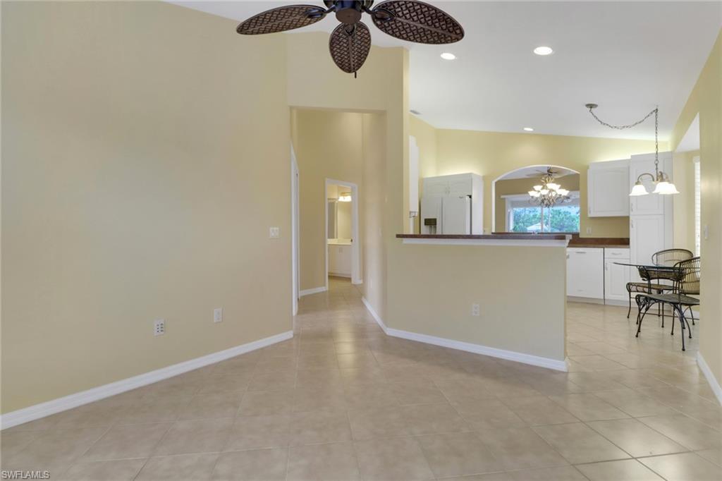 20141 Seagrove Street, Unit 308 Estero, FL 33928 - Photo 17 of 36 wooden floor in an empty room and a kitchen view
