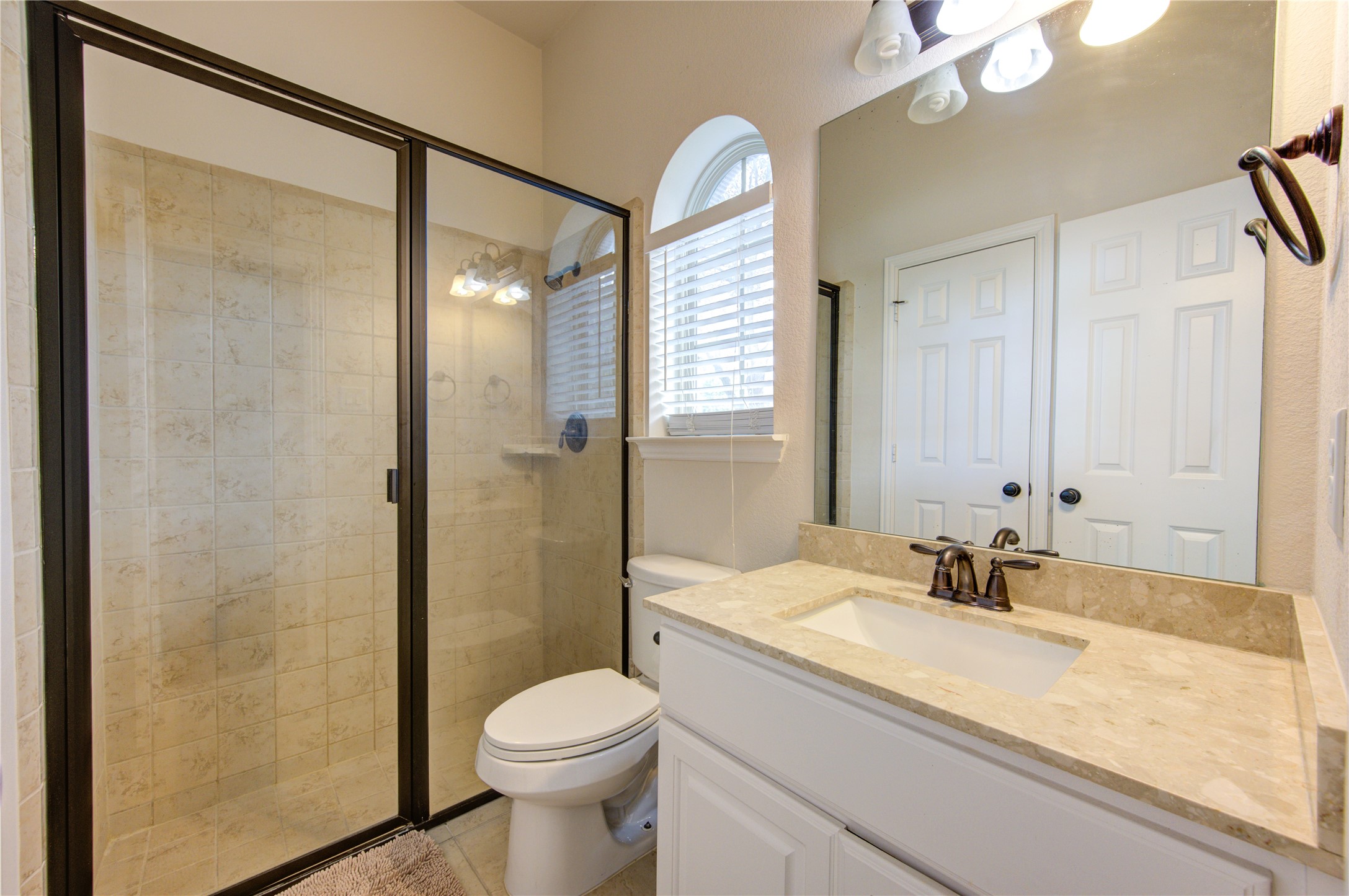 17539 Hankar Way Richmond, TX 77407 - Photo 23 of 34 a bathroom with a granite countertop sink toilet and shower