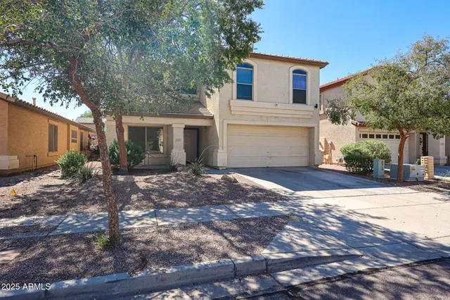 a front view of a house with a yard and a garage
