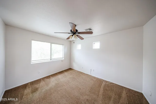 a view of a livingroom with a ceiling fan and window