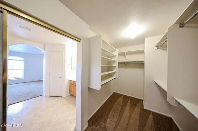a view of walk in closet with empty racks