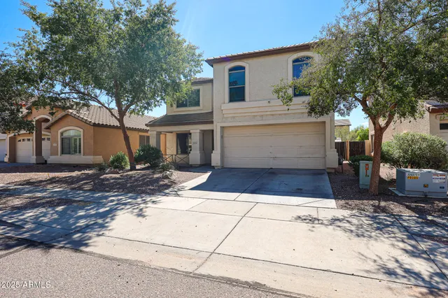 a front view of a house with a yard and trees
