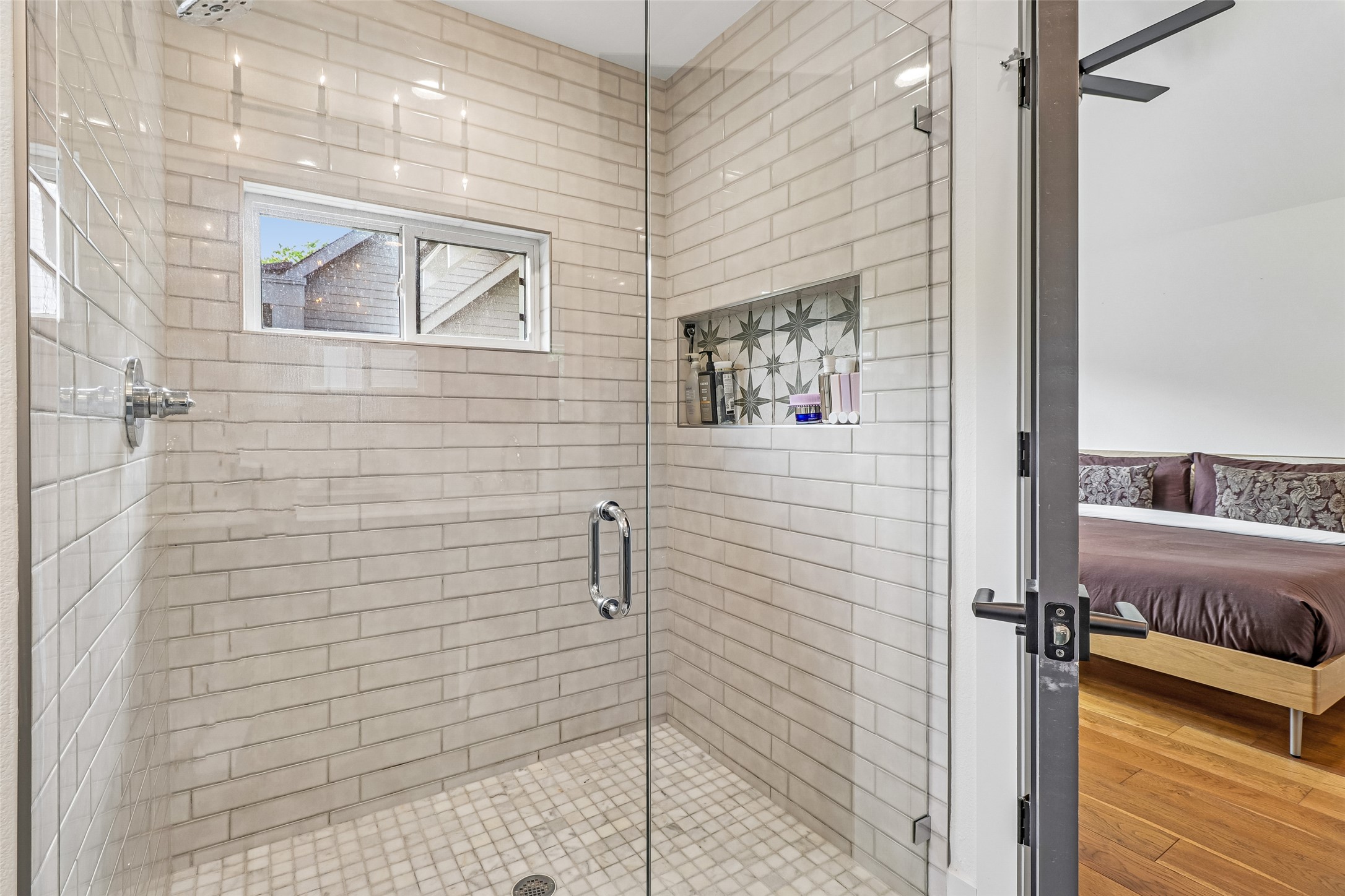 1706 Perez Street, Unit 1 Austin, TX 78721 - Photo 28 of 36 A glass-enclosed shower, adorned with subway tiles and featuring a tiled niche, creates a refreshing bathroom sanctuary.