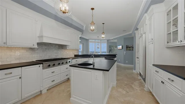 a kitchen with granite countertop a sink a stove and cabinets