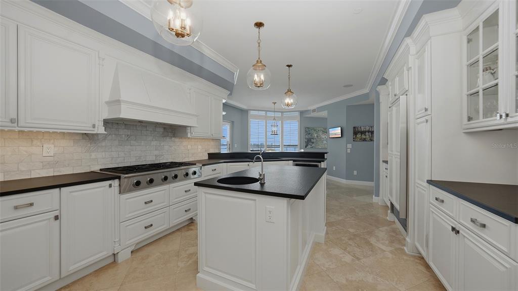 136 Golden Gate Point, Unit 502 Sarasota, FL 34236 - Photo 13 of 38 a kitchen with granite countertop a sink a stove and cabinets