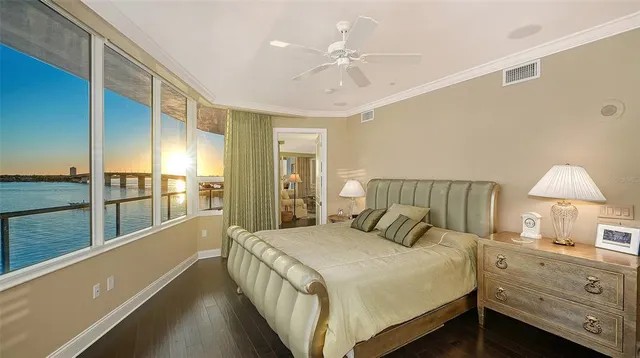 a bedroom with a large bed and a chandelier fan