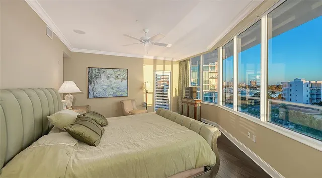 a bedroom with a large bed and a large window with the outer view