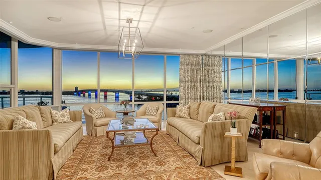a living room with furniture kitchen view and a chandelier