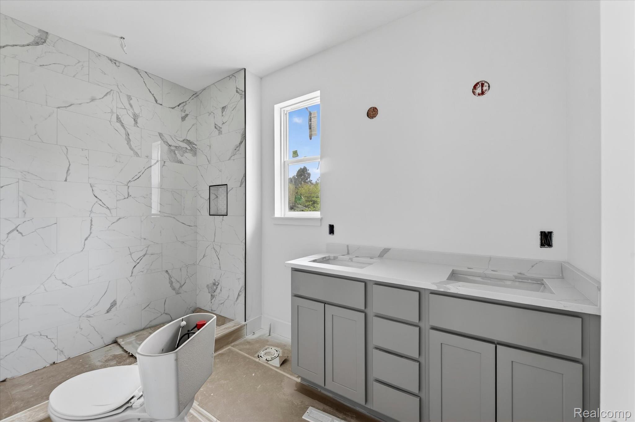 3297 Oak Grove Road Howell, MI 48855 - Photo 16 of 40 Primary bathroom with 2 sink vanity, quartz countertops, and floor-to-ceiling tiled walk-in shower.