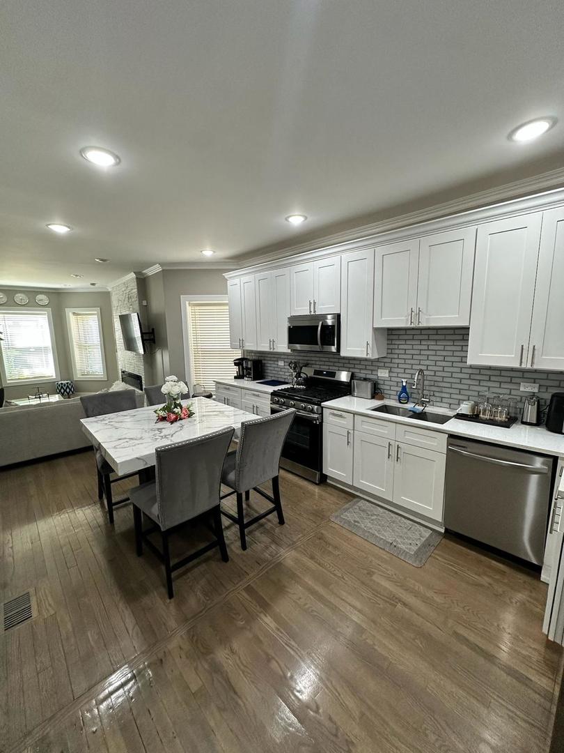 6807 South Calumet Avenue, Unit 1 Chicago, IL 60637 - Photo 3 of 17 a kitchen with a table chairs sink and microwave
