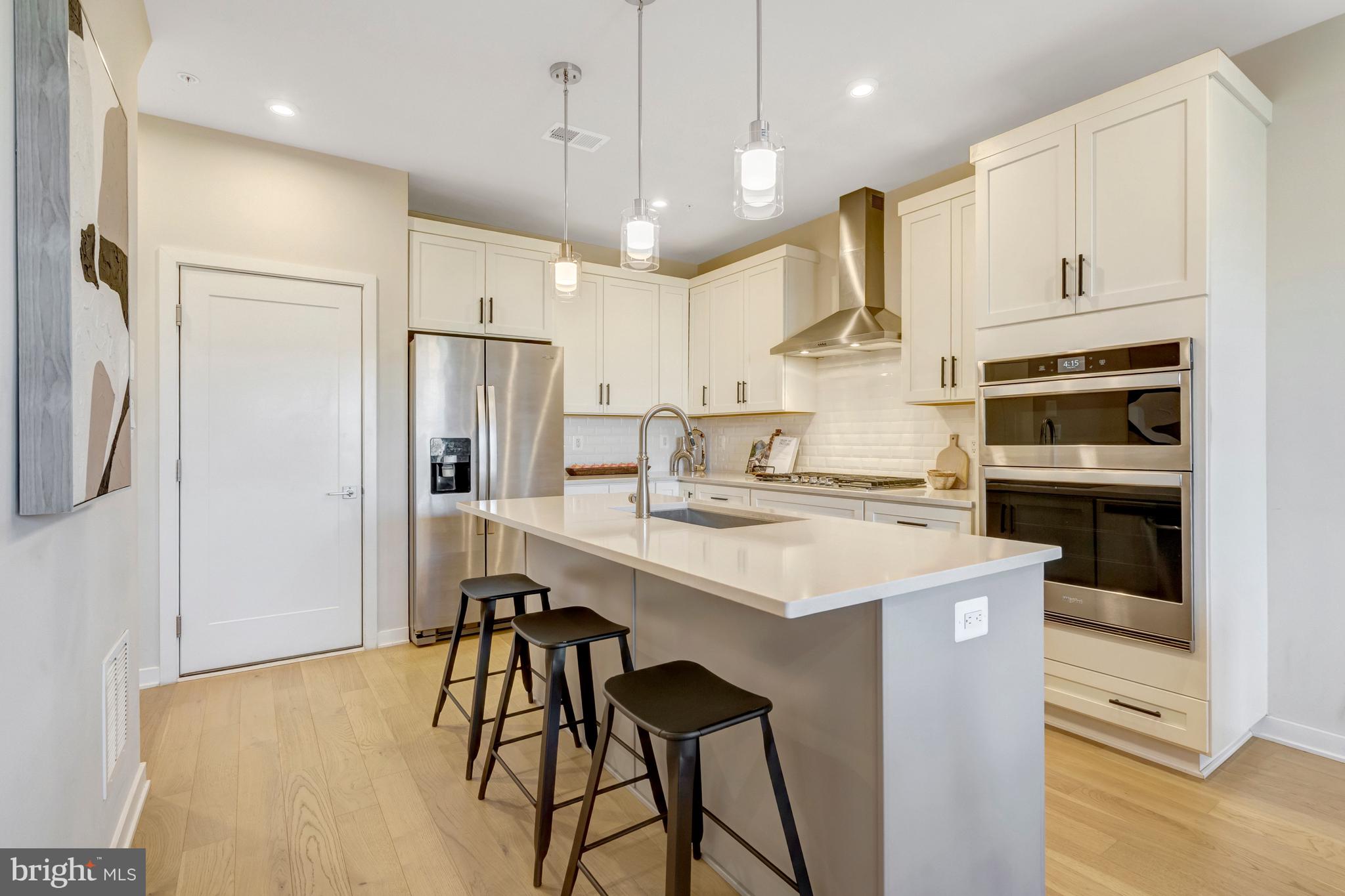 22379 Roanoke Rise Terrace Ashburn, VA 20148 - Photo 6 of 40 a kitchen with stainless steel appliances kitchen island a table chairs refrigerator and microwave