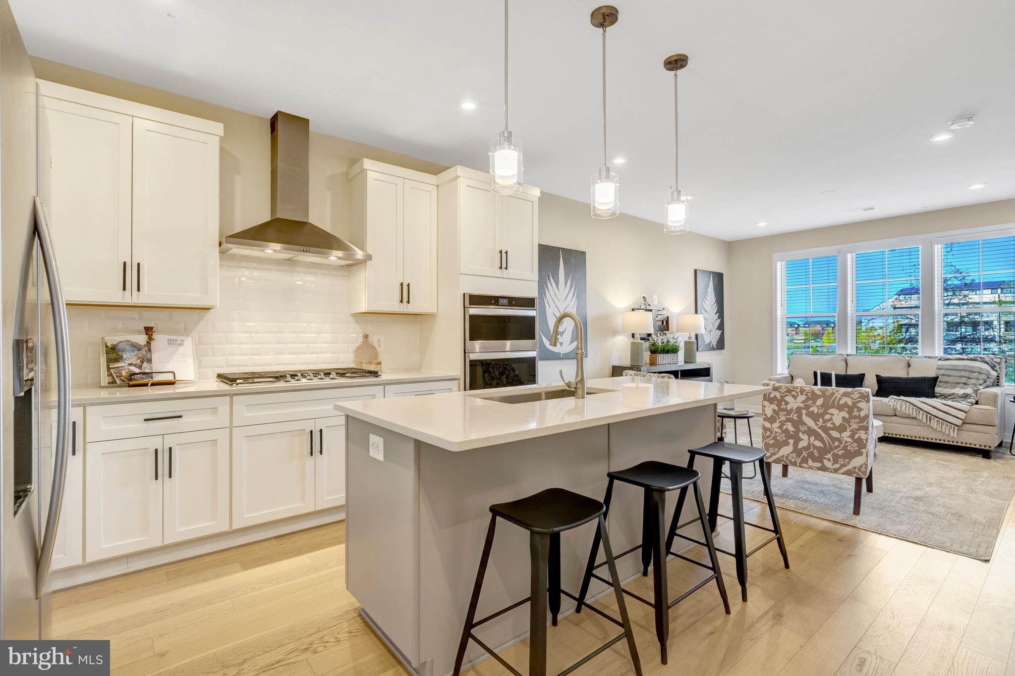22379 Roanoke Rise Terrace Ashburn, VA 20148 - Photo 7 of 40 a kitchen with stainless steel appliances granite countertop a stove a sink a refrigerator and white cabinets with wooden floor
