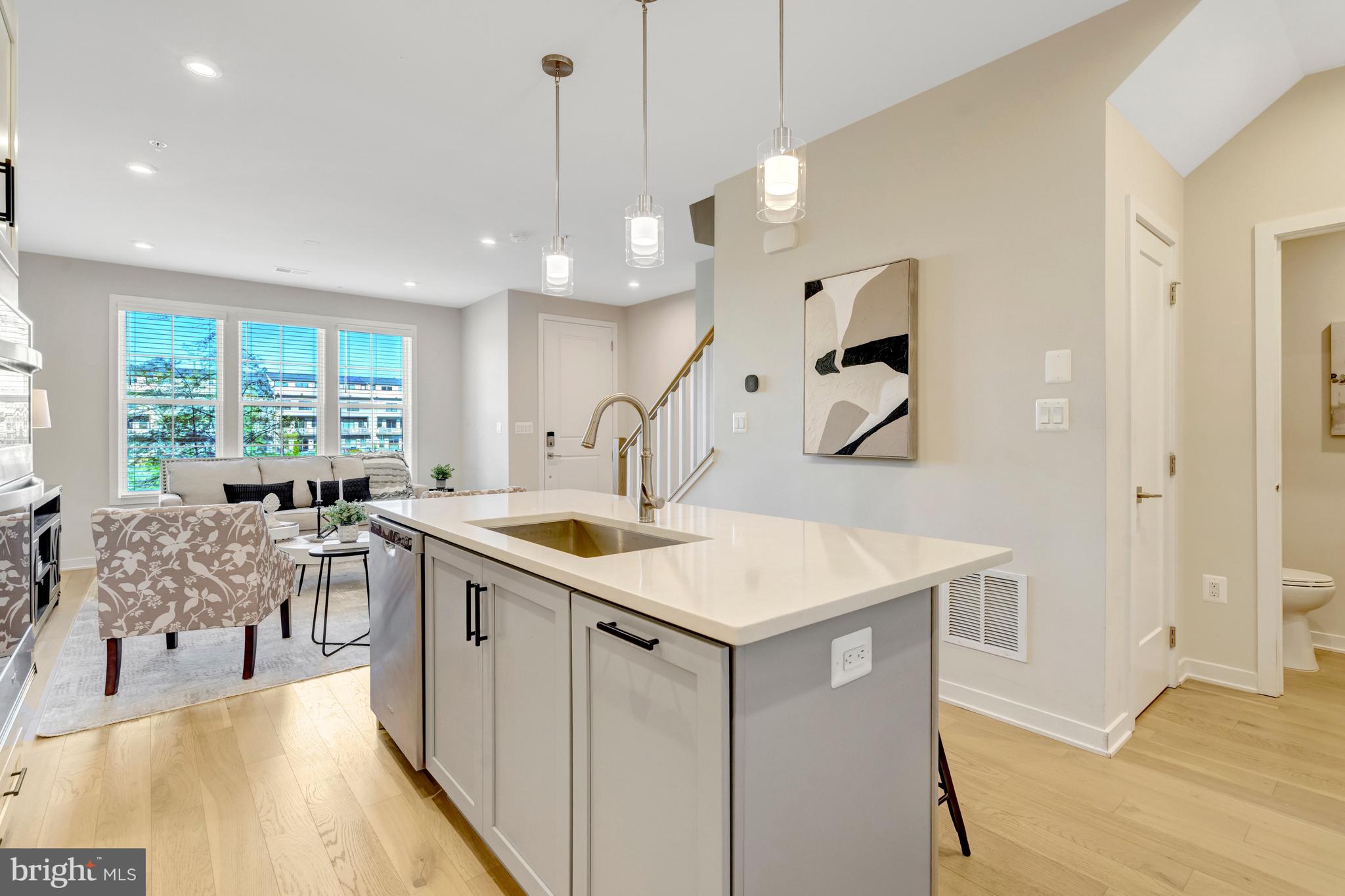 22379 Roanoke Rise Terrace Ashburn, VA 20148 - Photo 10 of 40 a kitchen with a stove a sink a dining table and chairs