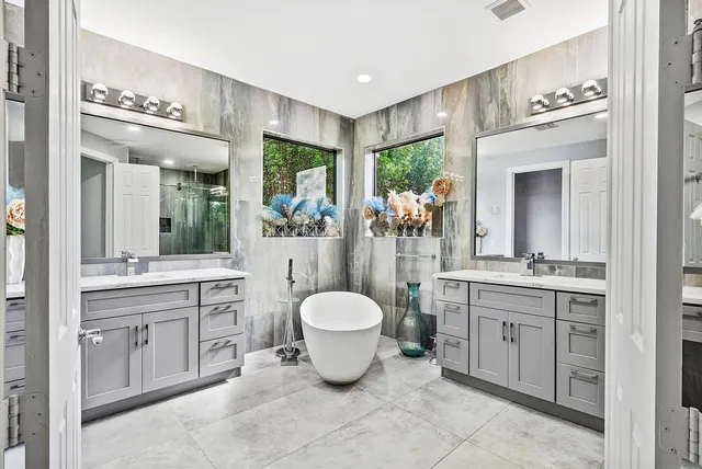 a spacious bathroom with a bathtub a sink and a large mirror