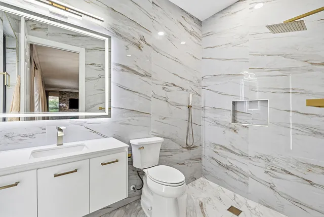 a bathroom with a sink a toilet and shower