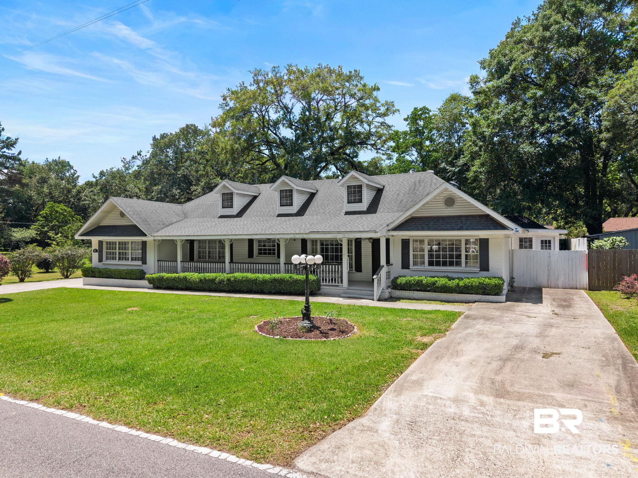 927 Cleveland Road Saraland, AL 36571 - Photo 75 of 80 Ranch-style residence featuring a prominent covered front porch, multiple dormer windows, and a dark shingle roof