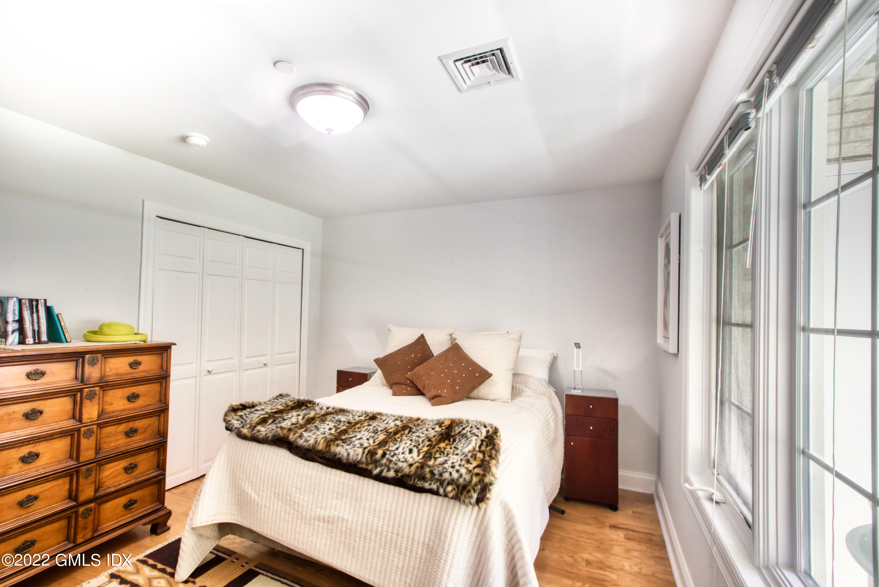 2 Homestead Lane, Unit 106 Greenwich, CT 06831 - Photo 17 of 25 a bedroom with a bed and wooden floor