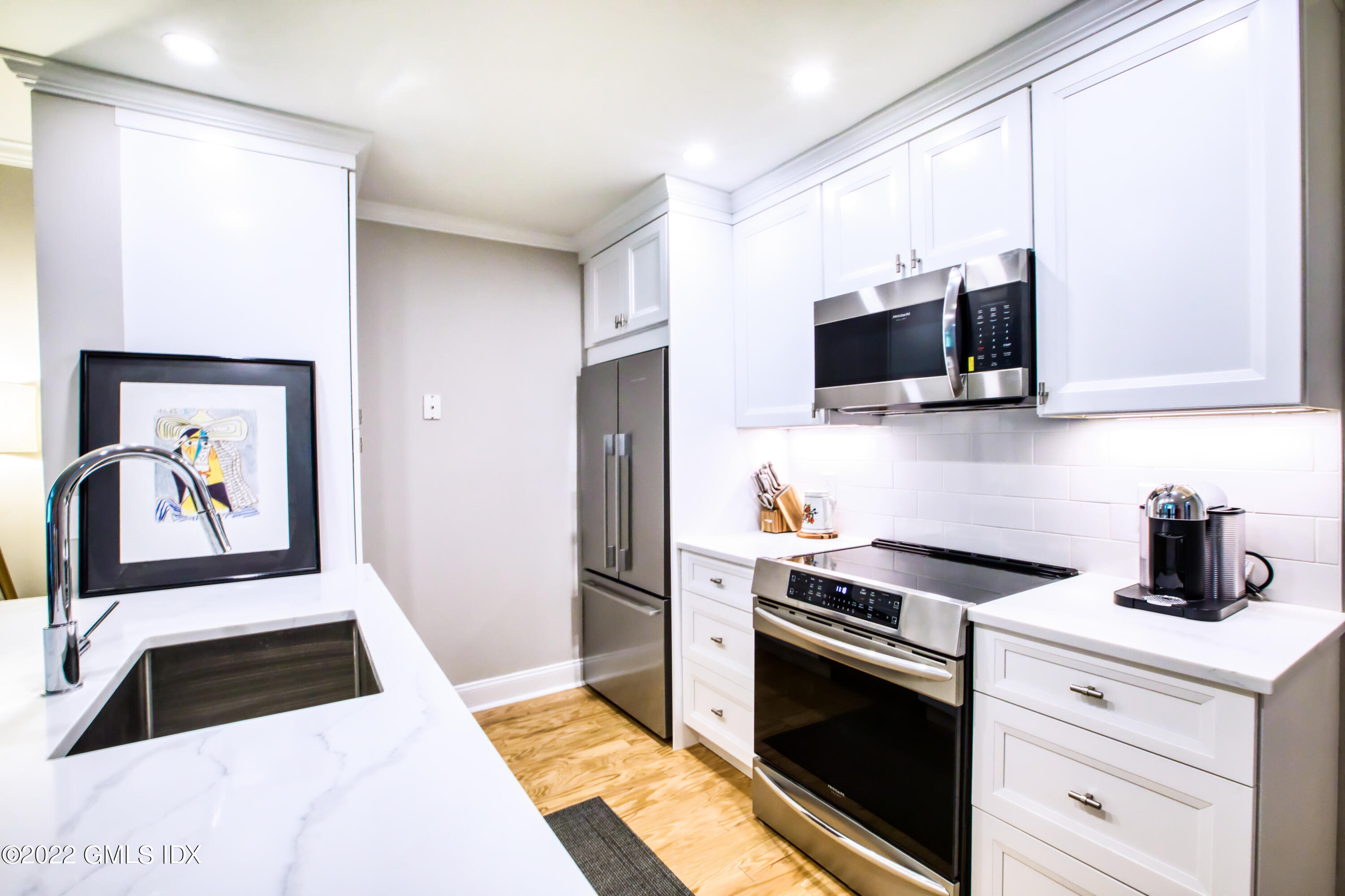 2 Homestead Lane, Unit 106 Greenwich, CT 06831 - Photo 4 of 25 a kitchen with stainless steel appliances a stove microwave and sink