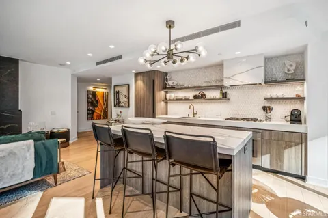 a kitchen with kitchen island granite countertop a sink stove and cabinets