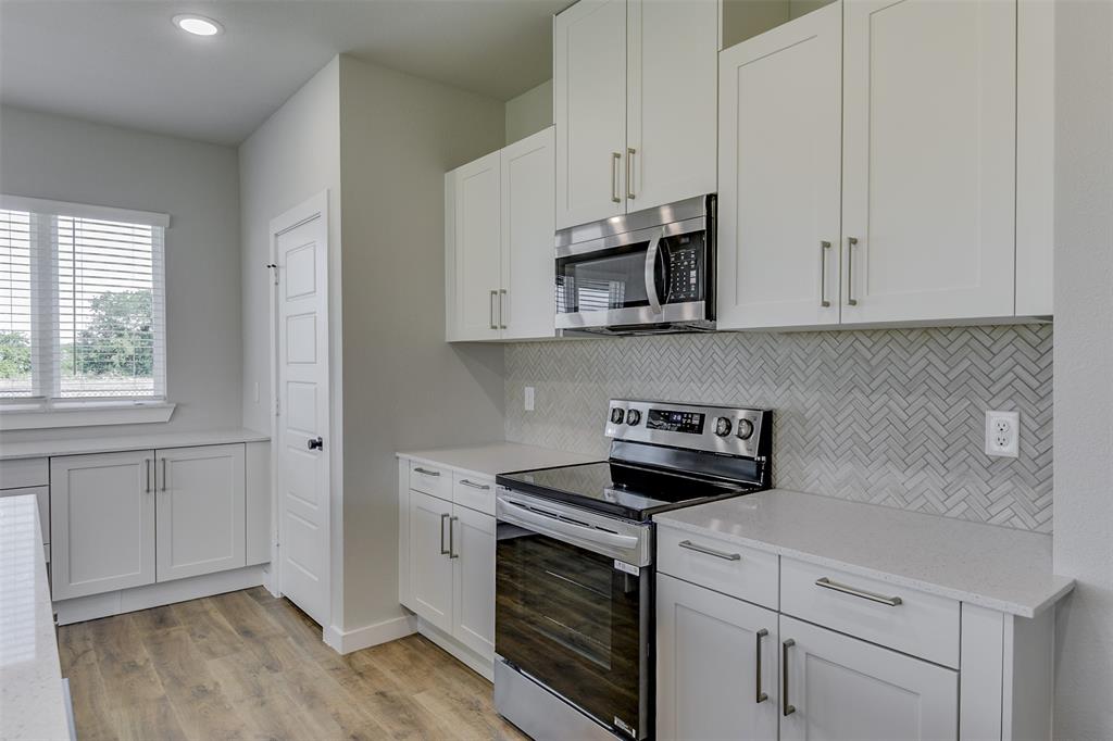 4240 Clovis Street Midlothian, TX 76065 - Photo 10 of 19 a kitchen with white cabinets stainless steel appliances and sink