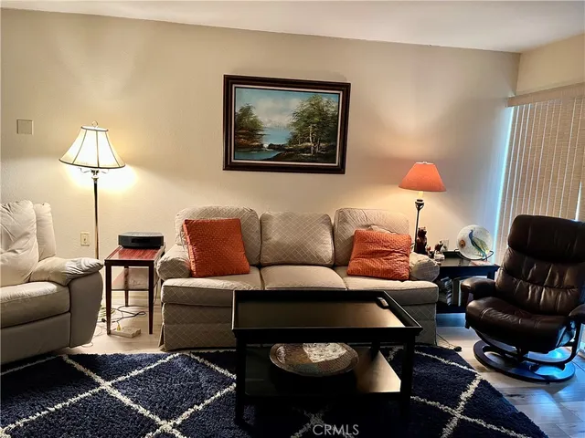 a living room with furniture a lamp and a rug