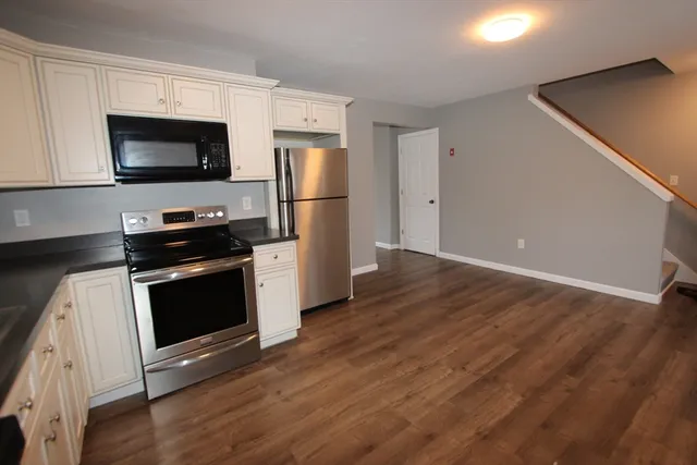 a kitchen with stainless steel appliances a stove a microwave and a hard wood floor