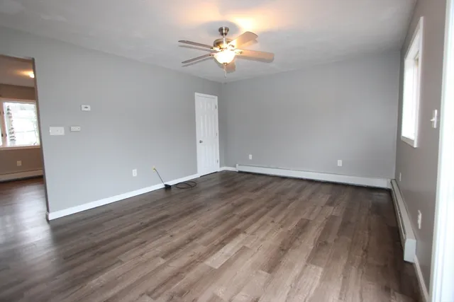 a view of a room with wooden floor and a ceiling fan