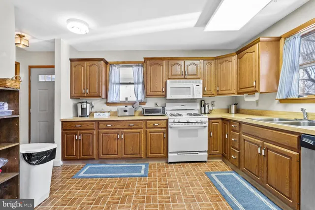 a living room with lots of furniture and view of kitchen