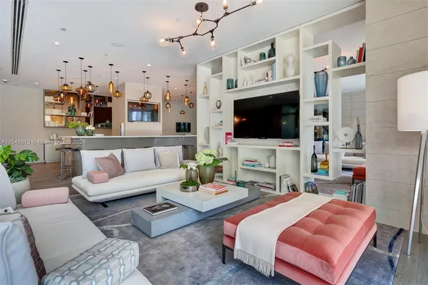 a living room with furniture a fireplace and a chandelier