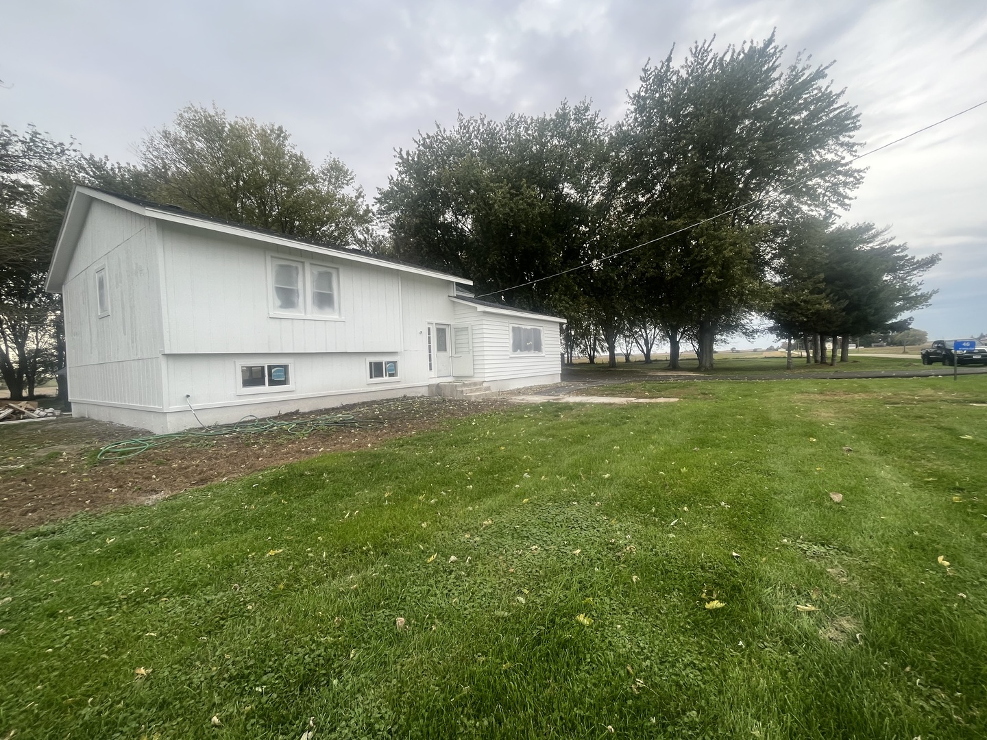 46 North 46th Road Mendota, IL 61342 - Photo 32 of 48 a white house that has a big yard with large trees