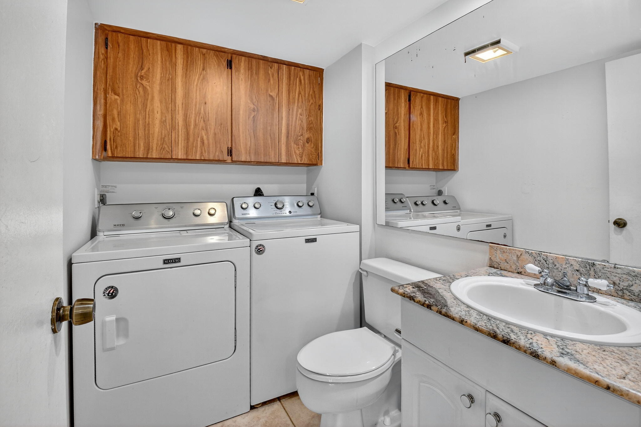 2907 Southwest 22nd Circle, Unit 39D Delray Beach, FL 33445 - Photo 11 of 57 a bathroom with a granite countertop sink toilet and mirror