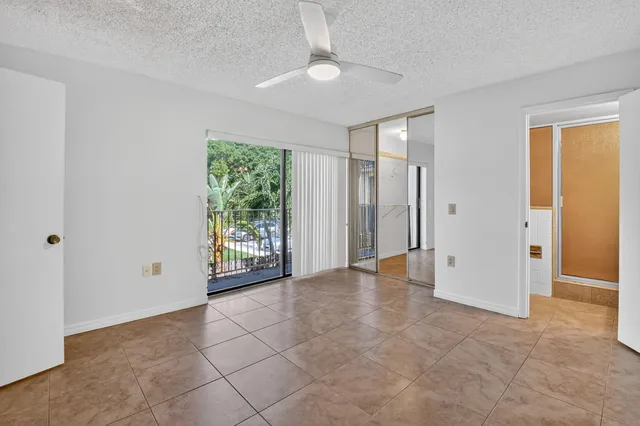 an empty room with closet and a chandelier fan