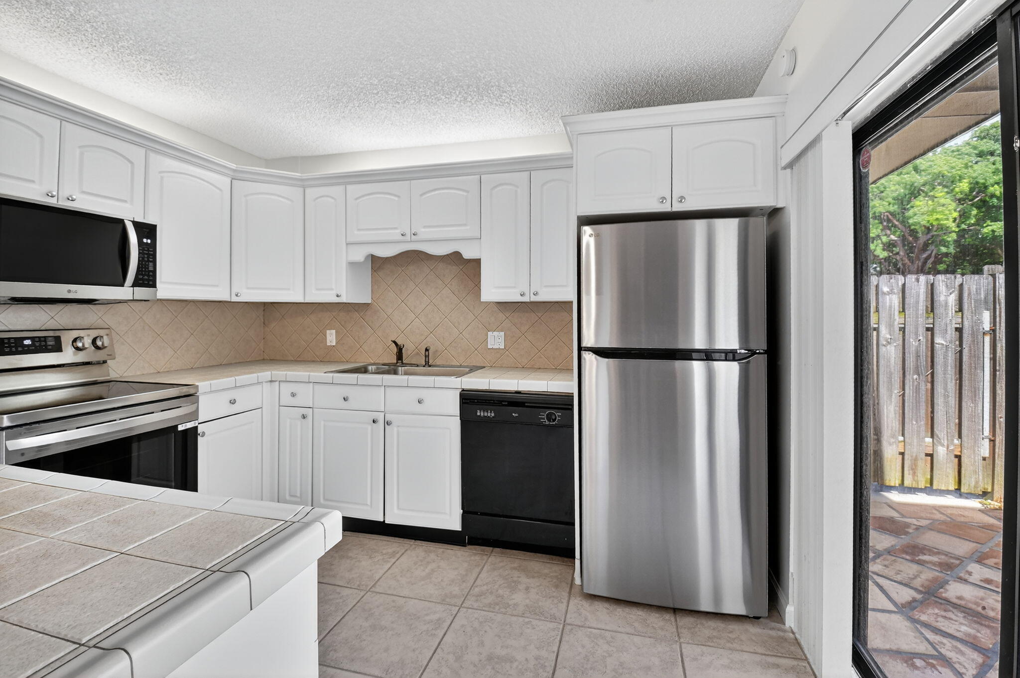 2907 Southwest 22nd Circle, Unit 39D Delray Beach, FL 33445 - Photo 2 of 57 a kitchen with a refrigerator stove and microwave
