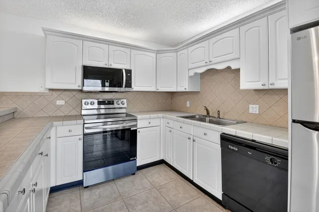 a kitchen with white cabinets and stainless steel appliances