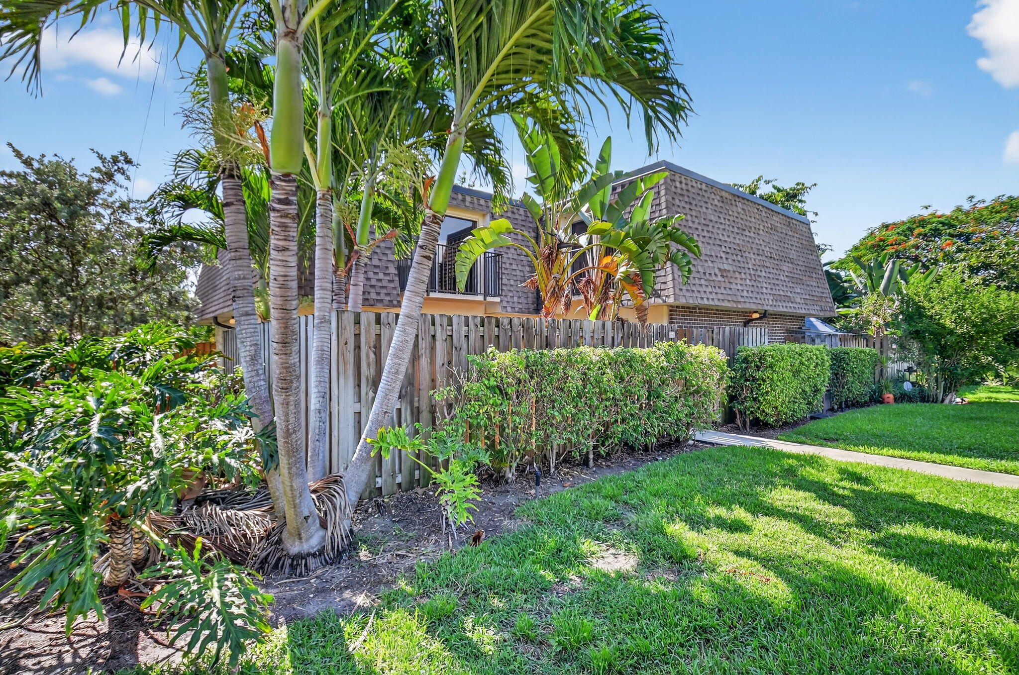 2907 Southwest 22nd Circle, Unit 39D Delray Beach, FL 33445 - Photo 32 of 57 a view of a yard with plants and a large tree