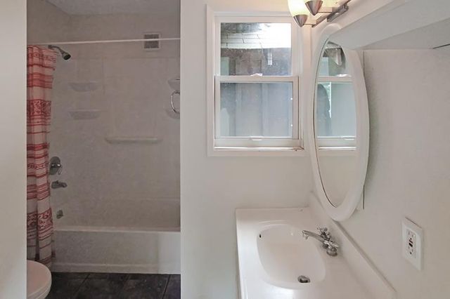 a view of an empty room with cabinet and a window