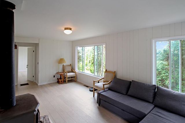 an empty room with a window and wooden floor