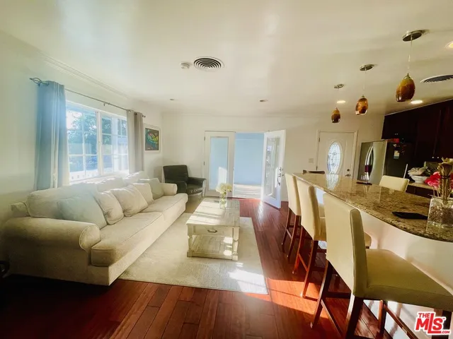 a kitchen with stainless steel appliances a dining table chairs refrigerator and sink