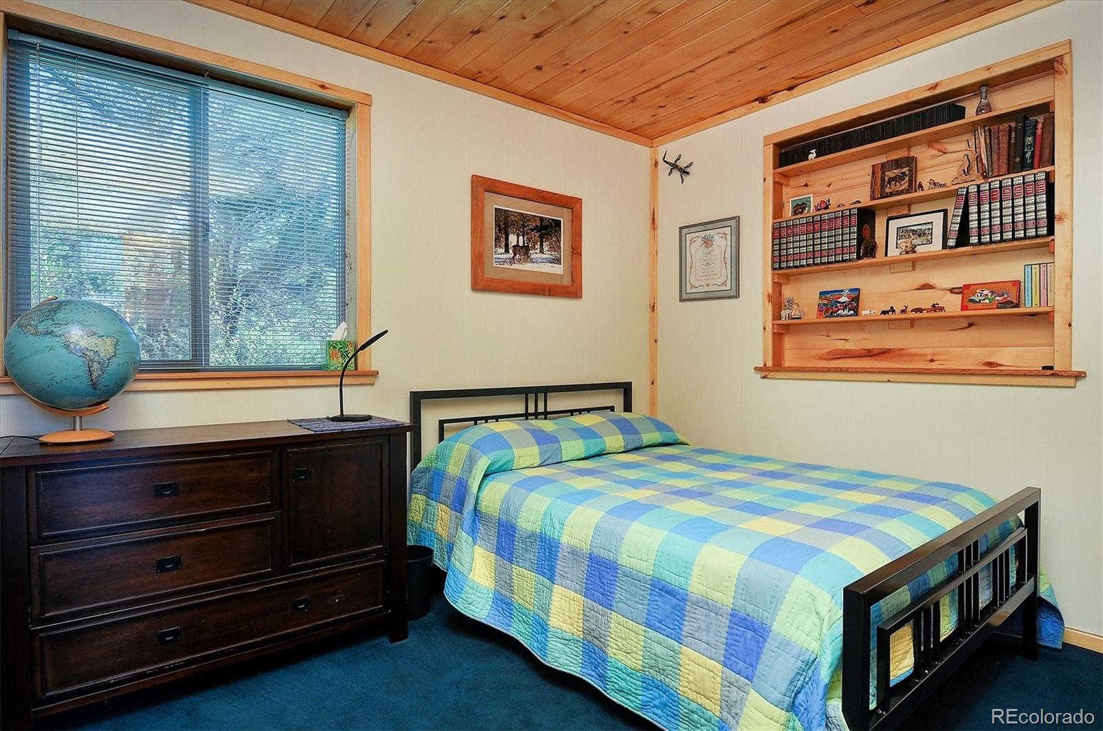 1111 Red Feather Road Cotopaxi, CO 81223 - Photo 17 of 37 a bedroom with a bed and wooden floor